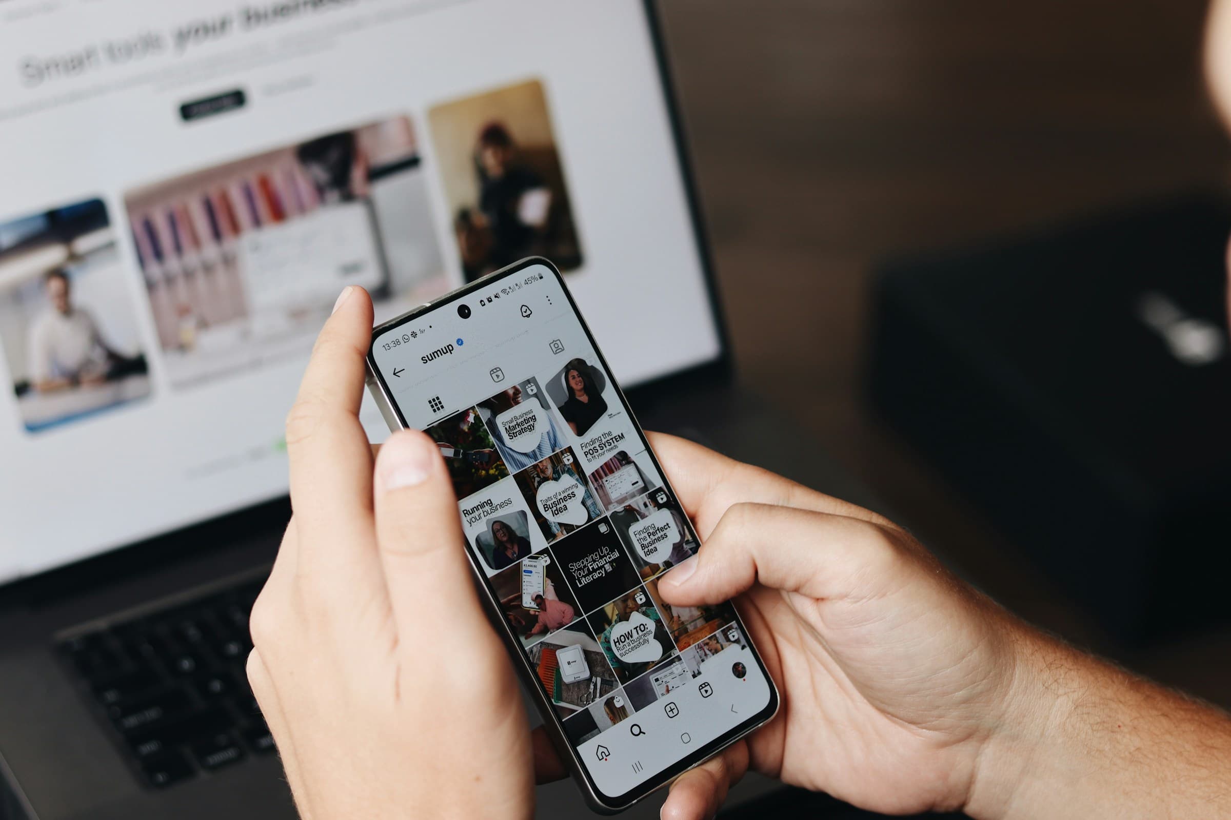 Un téléphone affiche une publication devant un ordinateur portable